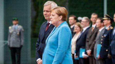 "Менің қолымнан келеді": Маман Меркельдің үшінші рет қалтырағанда не деп сыбырлағанын айтты